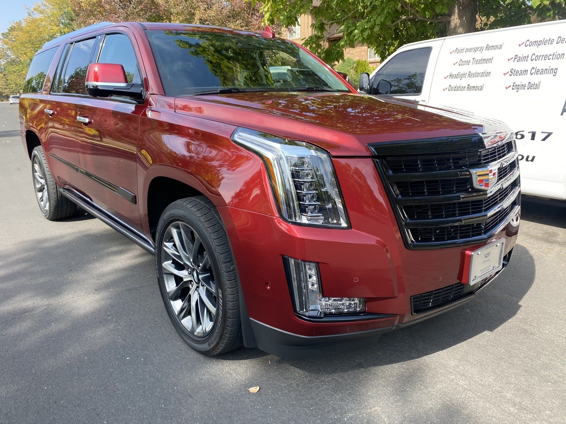 a red cadillac escalade is parked on the side of the road