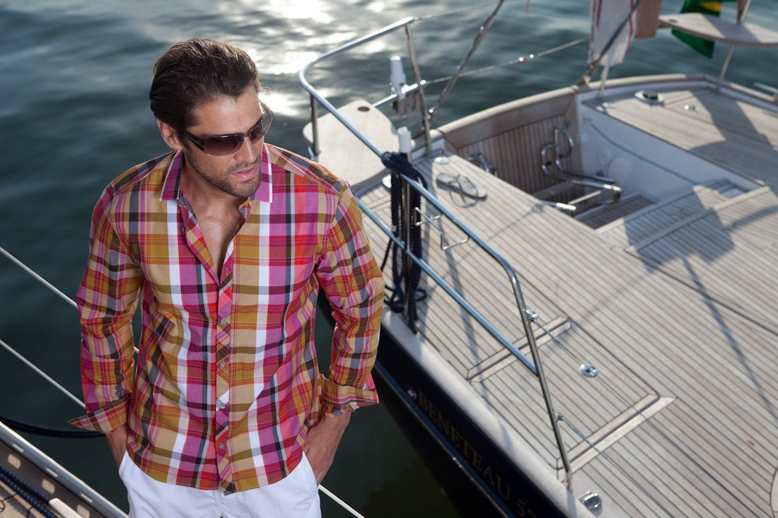 Um homem de camisa xadrez está em um barco