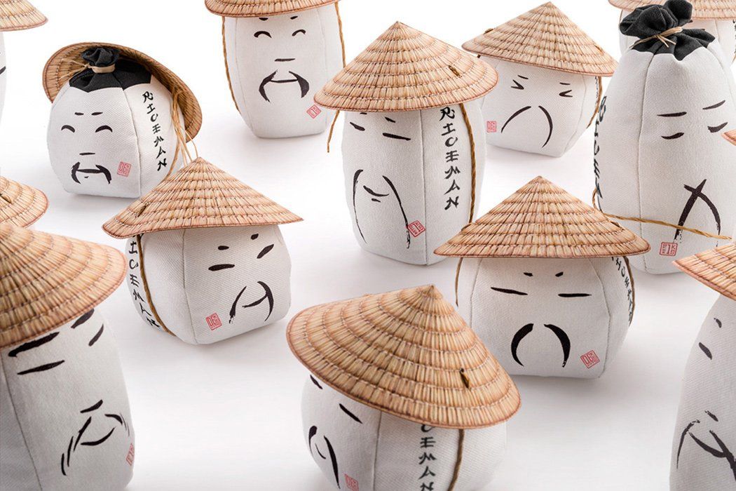 Um grupo de bolinhos de arroz usando chapéus de palha com escrita chinesa neles