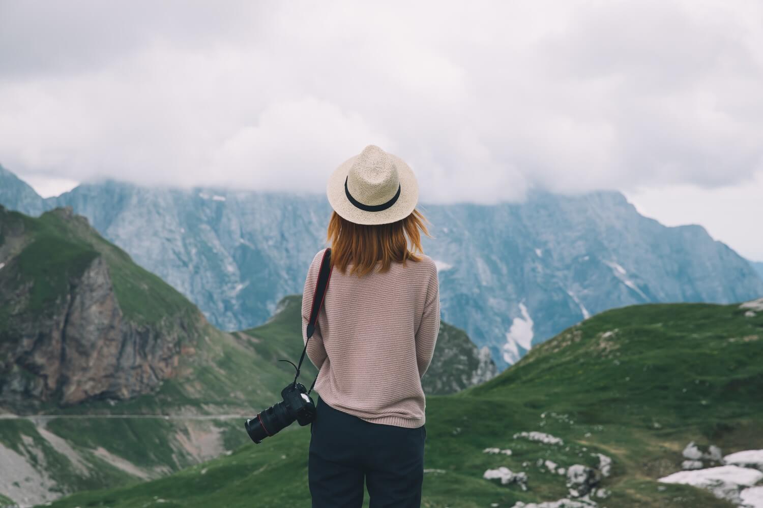 una ragazza che guarda un paesaggio di montagna