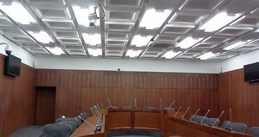 Una sala de conferencias con una mesa larga y sillas y un techo.