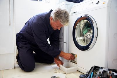 Repairman Fixing The Dryer — Dyer, IN — Anderson Appliance Repair Repairman Fixing The Dryer — Dyer, IN — Anderson Appliance Repair