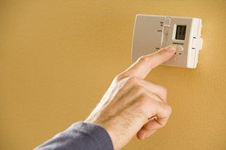 Person Adjusting Thermostat - Heating Contractor in Ona, WV Person Adjusting Thermostat - Heating Contractor in Ona, WV