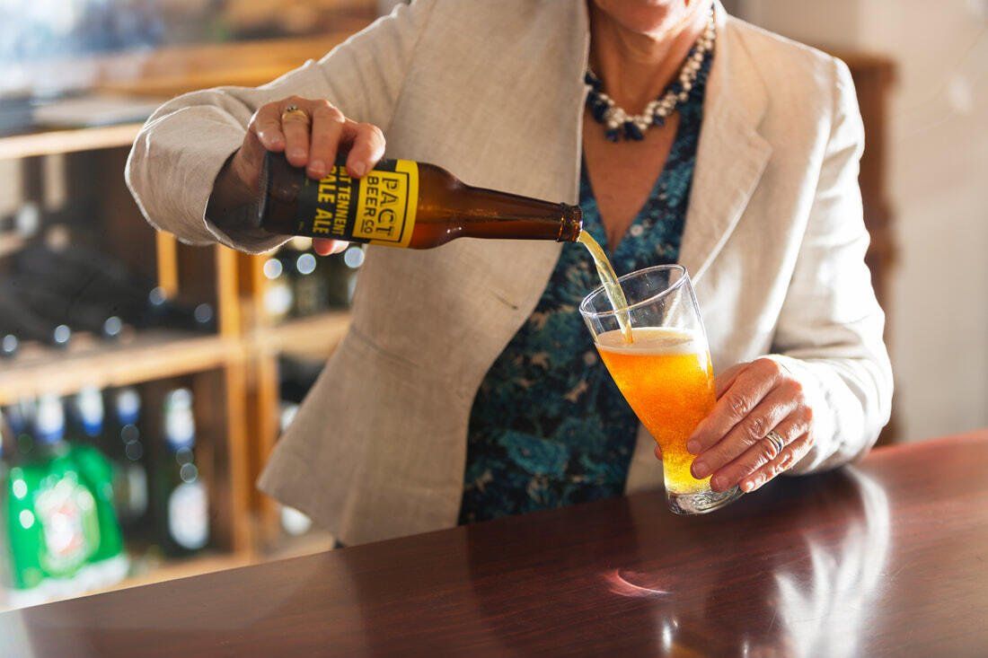 Bartender pouring beer into a cocktail glass at a bar