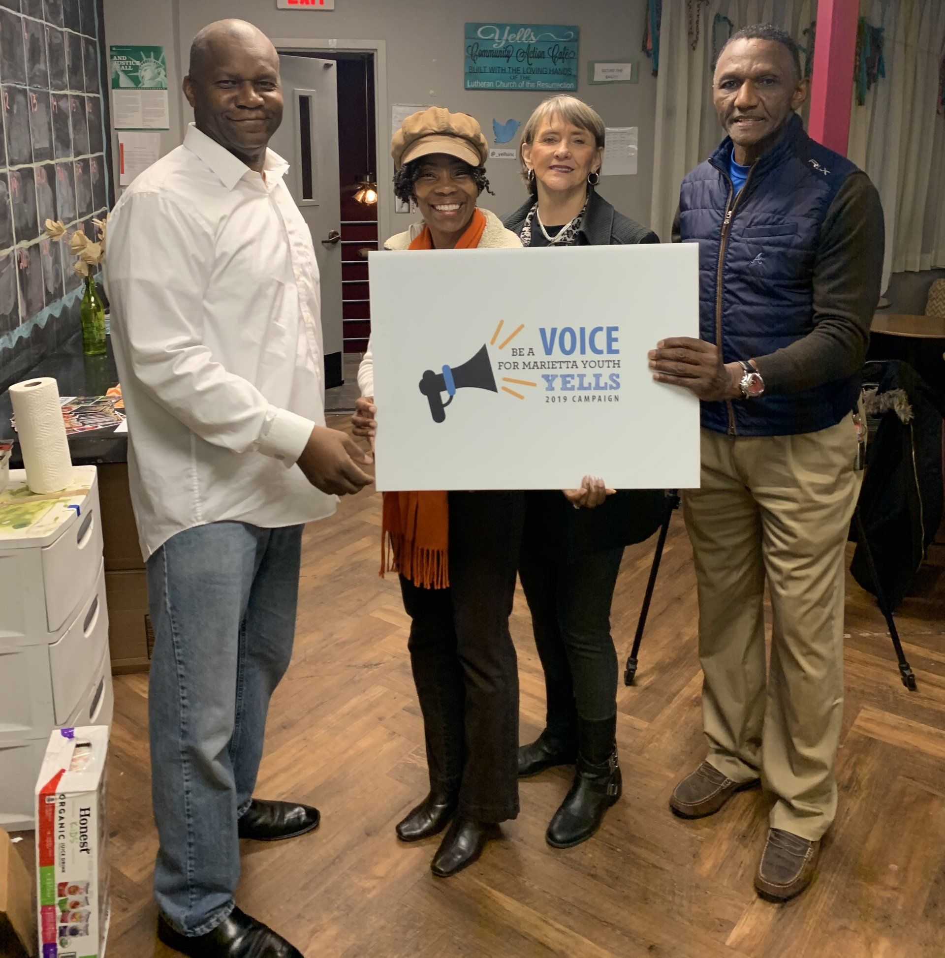 A group of people holding a sign that says voice tell