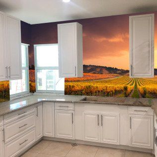 White kitchen with granite counters and a sunset vineyard mural backsplash