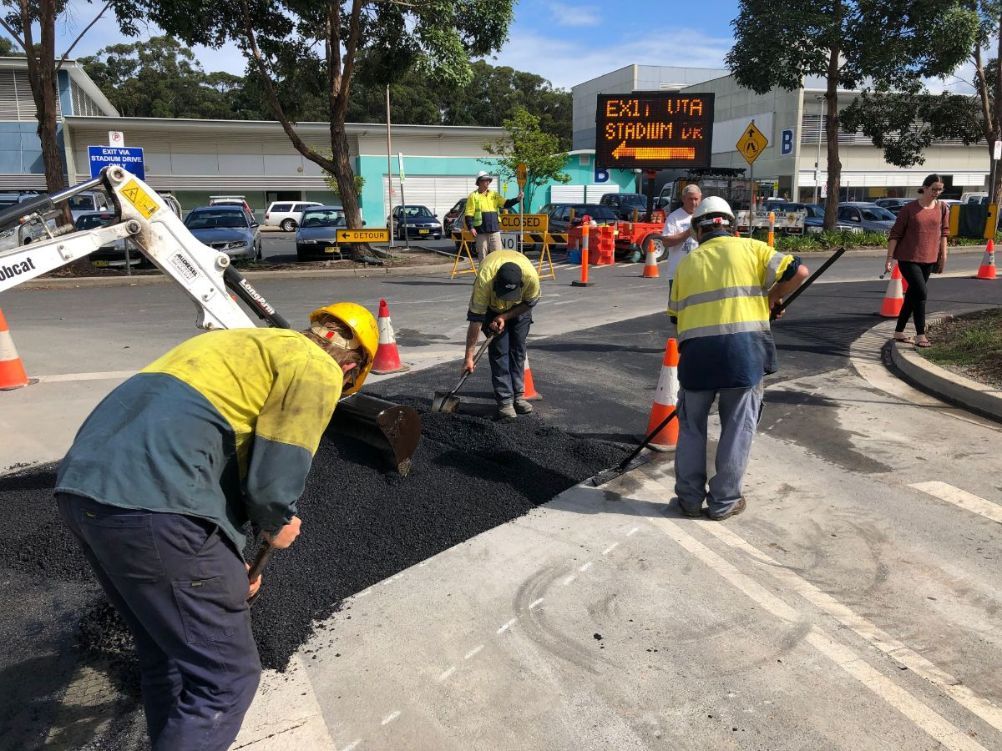 A group of construction workers are working on a road.