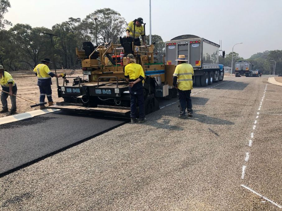 A group of construction workers are working on a road