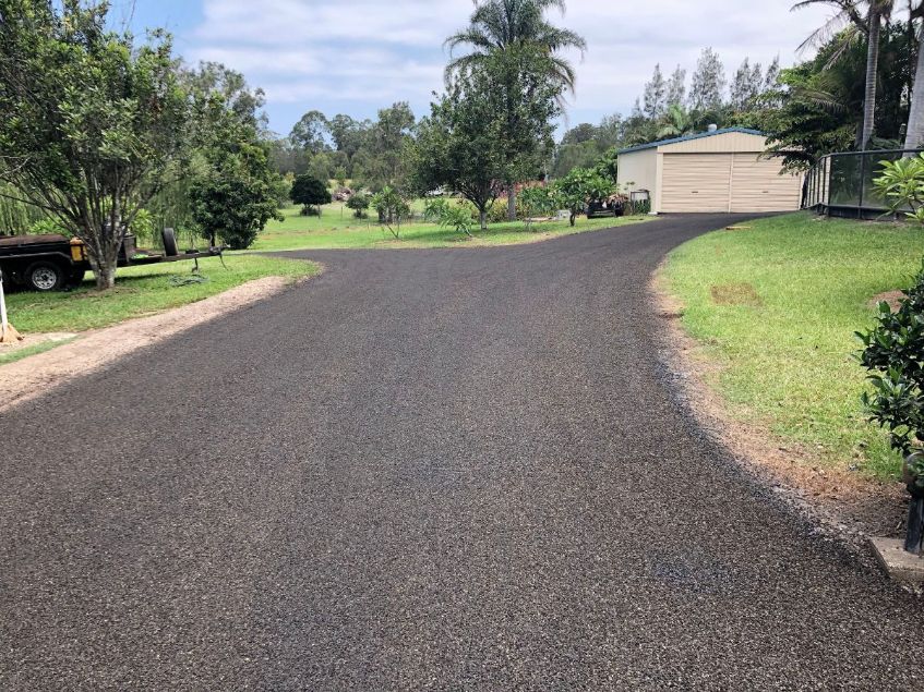 A black car is parked on the side of a road.
