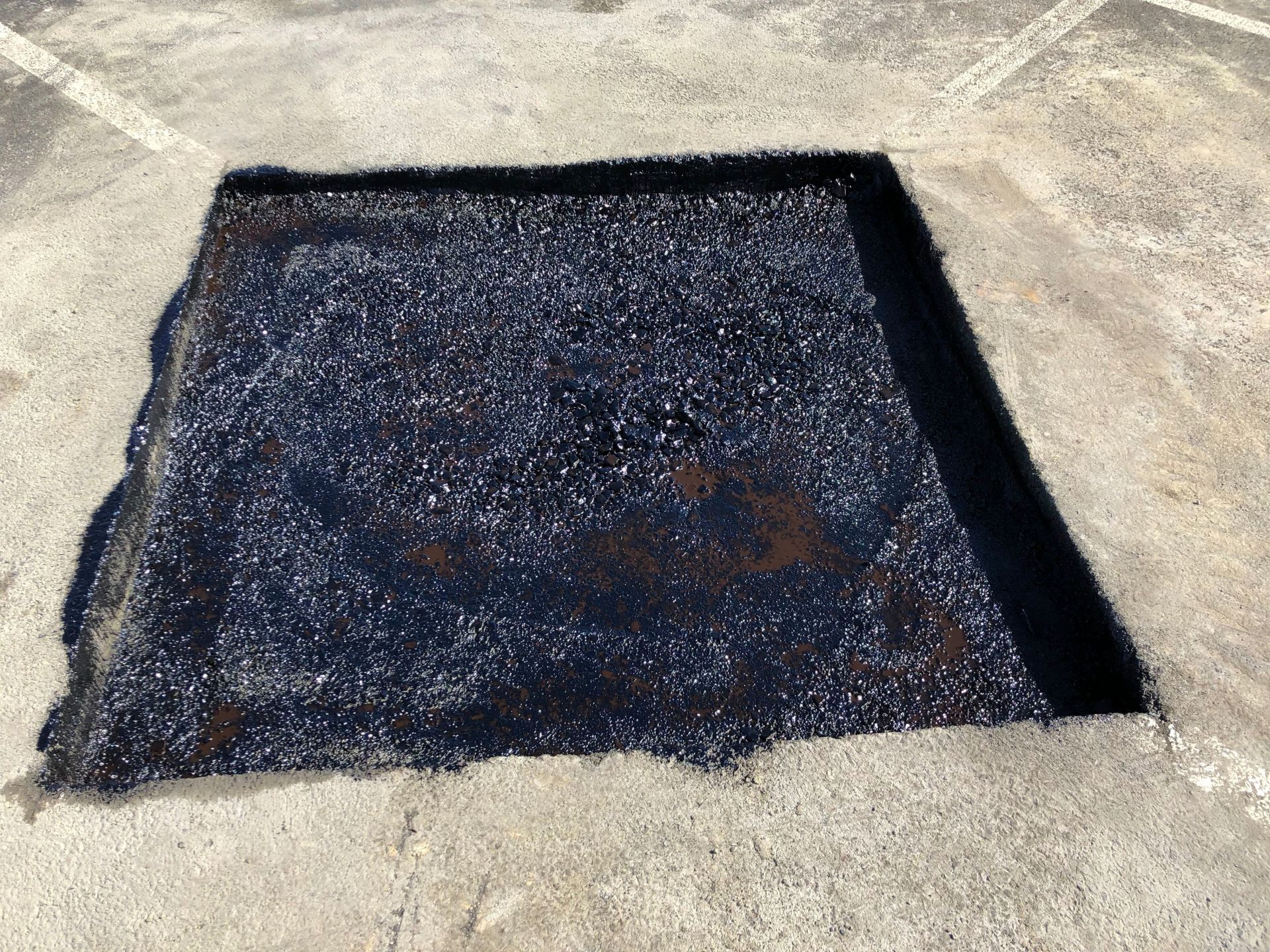 A piece of asphalt is sitting on top of a concrete surface.