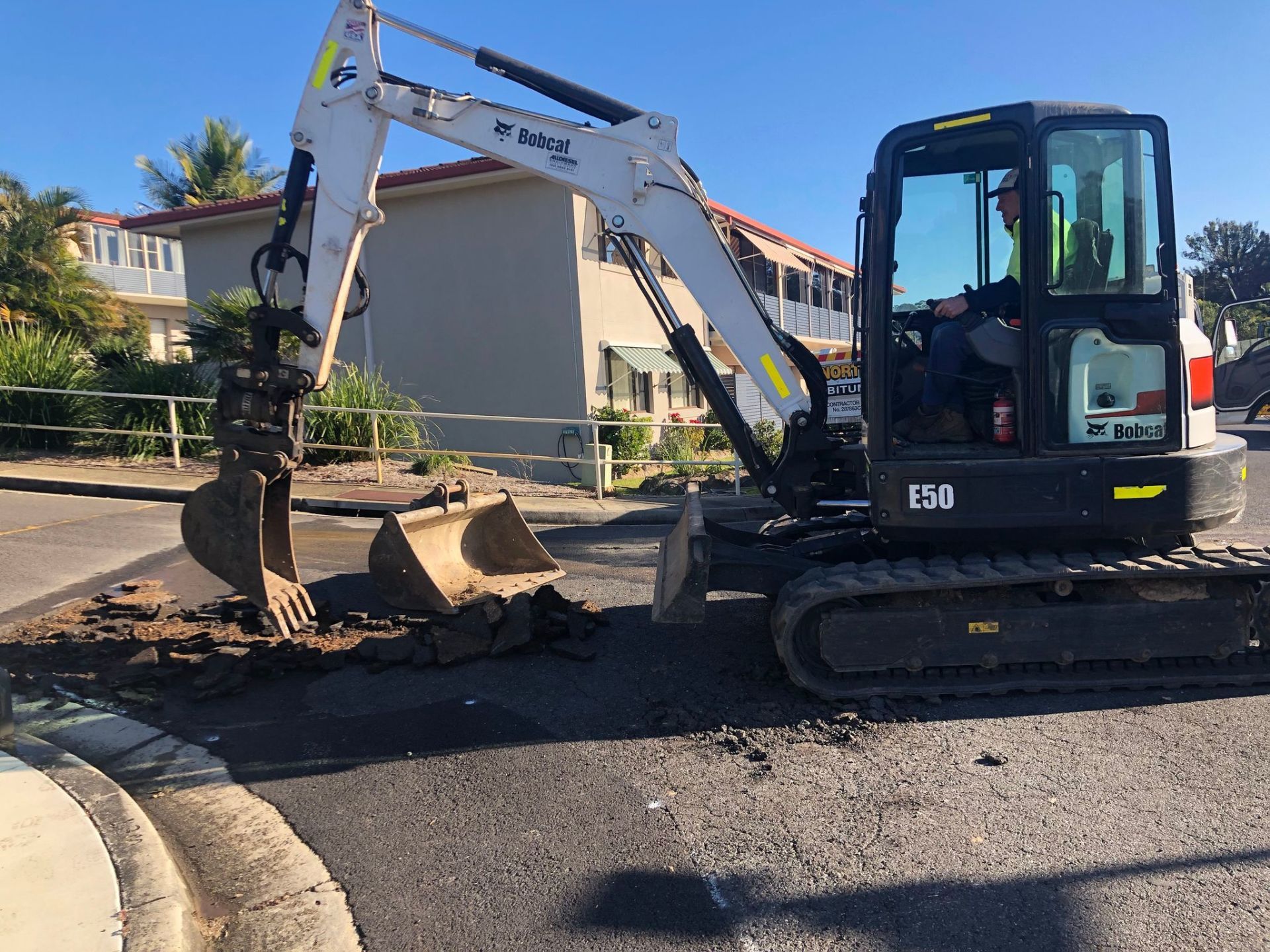 A small excavator is parked on the side of the road.