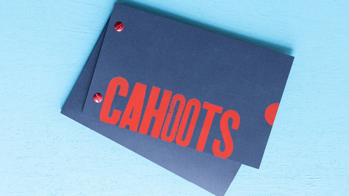 Two dark gray cards on a blue surface with the word 