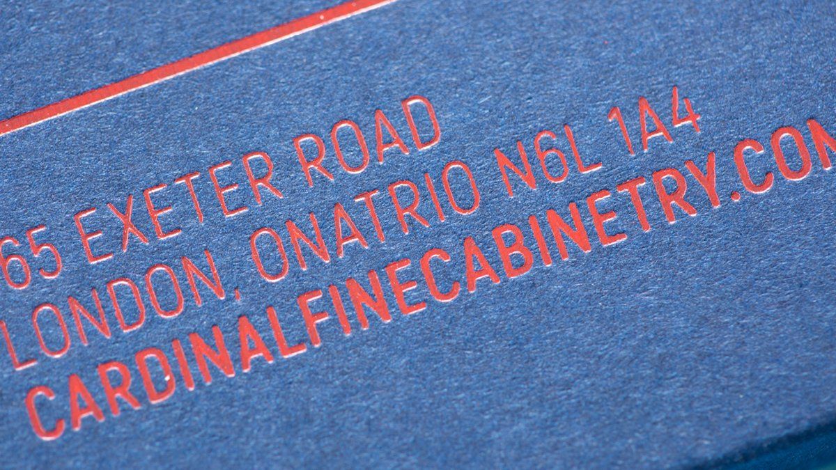 Red text on blue background: business card with address for Cardinal Fine Cabinetry in London.