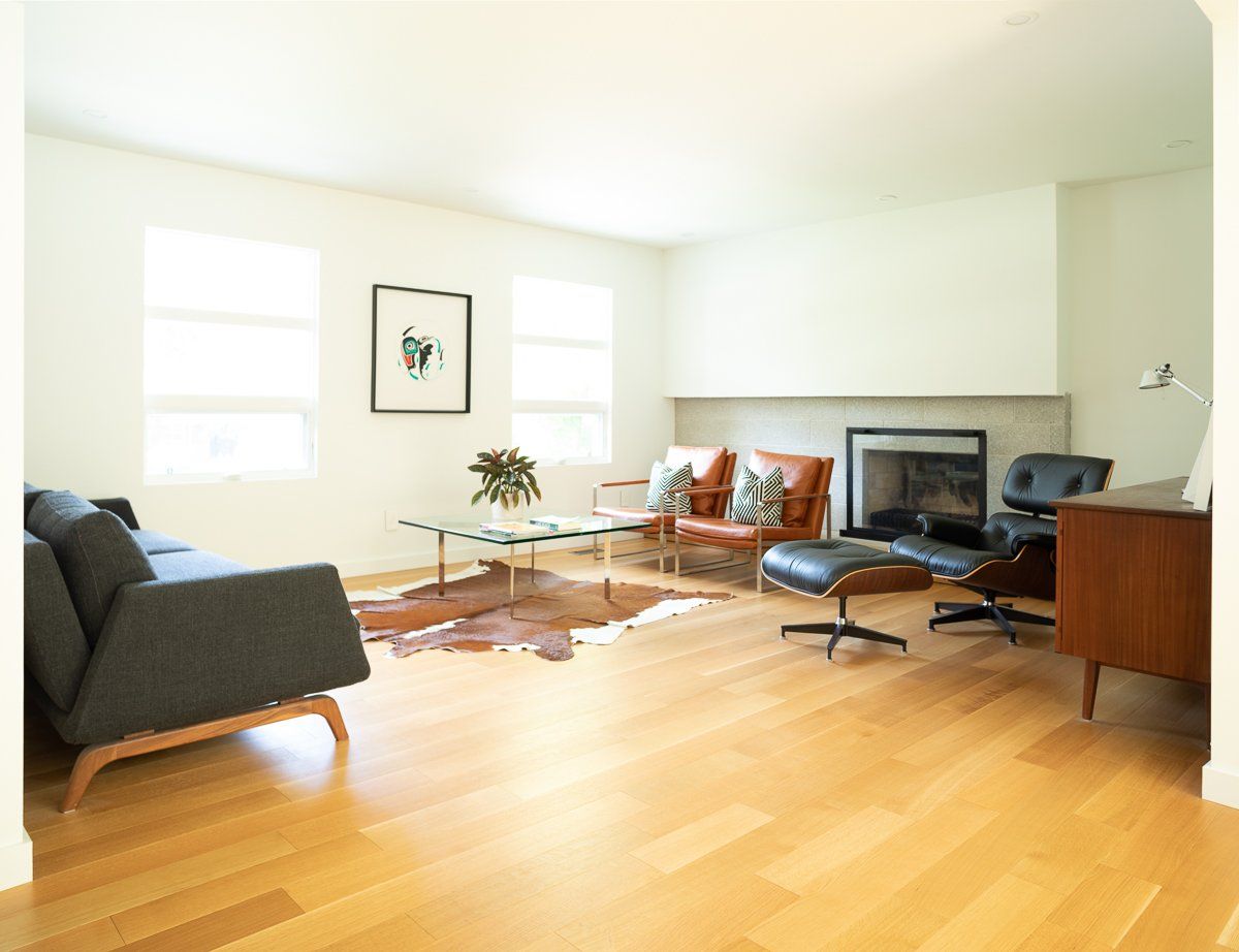 Modern living room with wood floors, fireplace, and mid-century furniture.