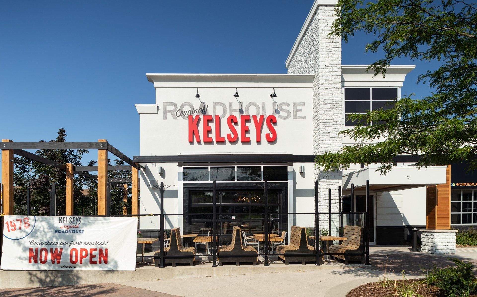 Kelseys Roadhouse restaurant exterior with a patio, red sign on a white building, and 