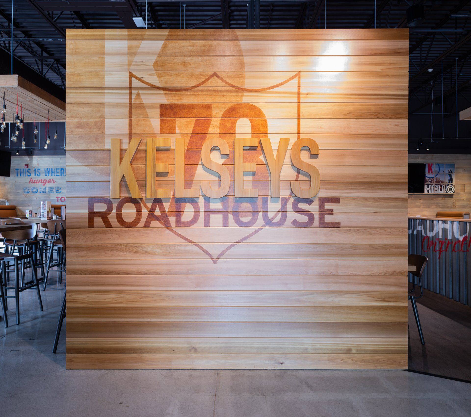 Kelseys Roadhouse logo on a wood-paneled wall inside a restaurant.