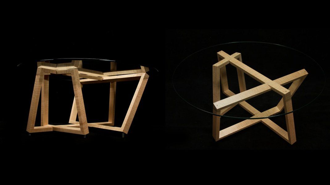 Two modern wooden tables with glass tops against a black background. One is angular, the other crisscrossed.