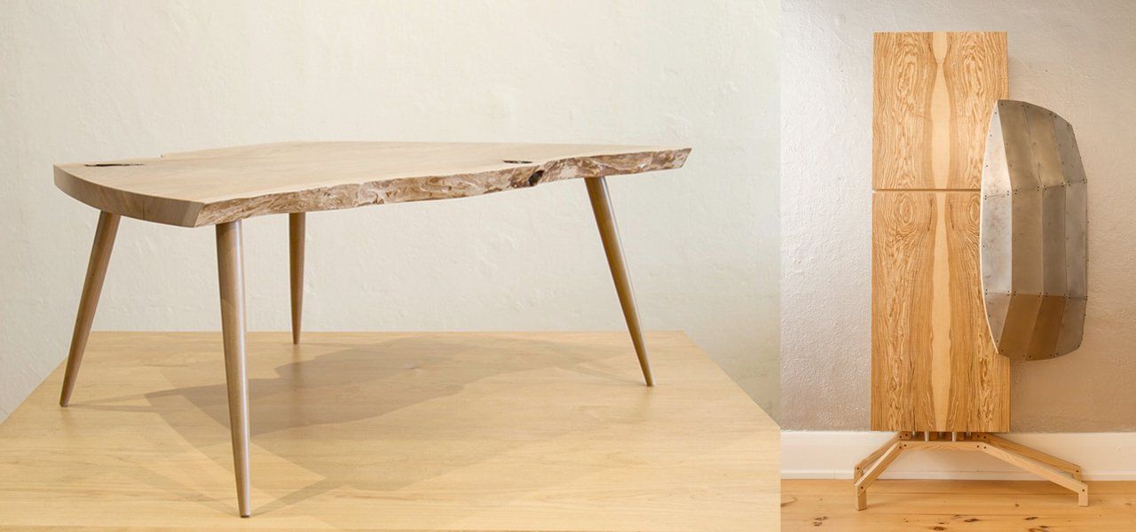 Wooden table with angled legs and a wood panel with a curved metal element.