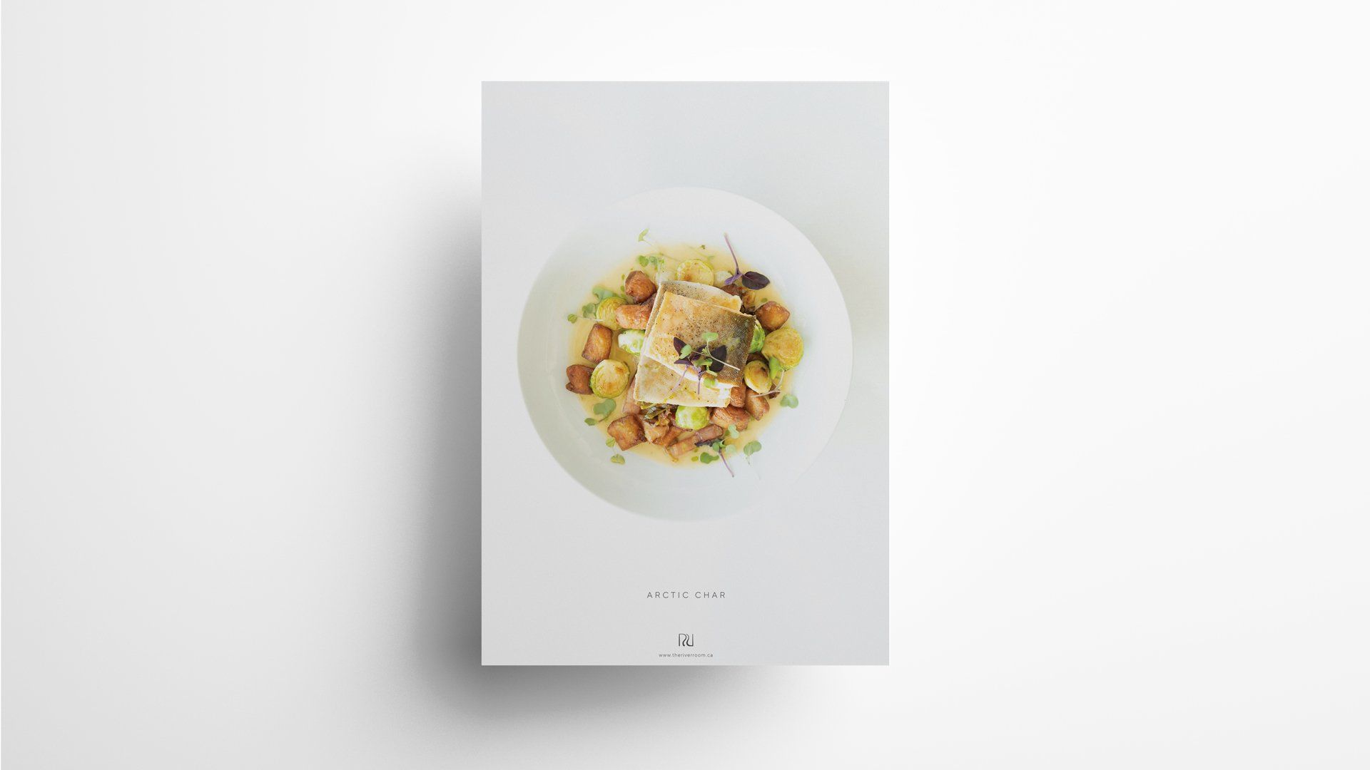 White plate of food on a white background. The food appears to be a salad with a crouton and other garnishes.