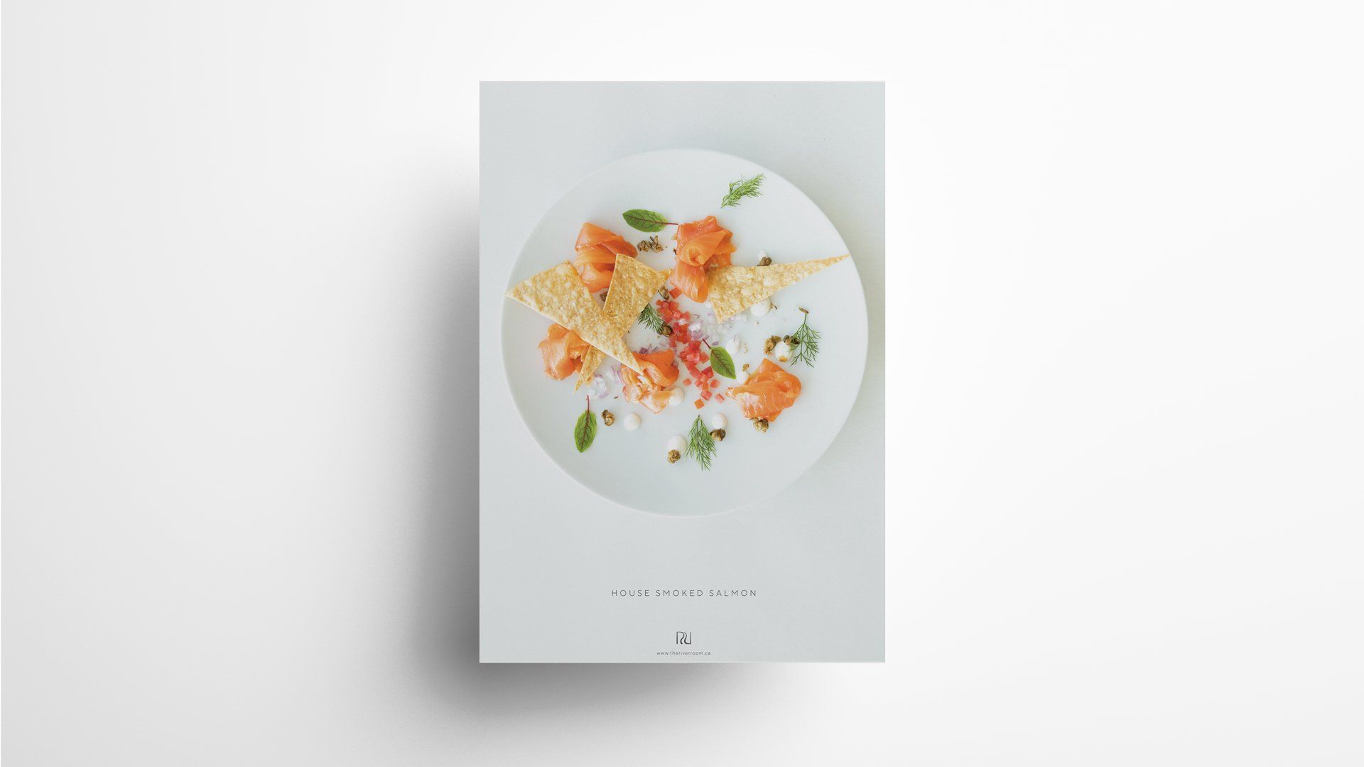 White plate with gourmet food; salmon, crispy cracker, herbs.