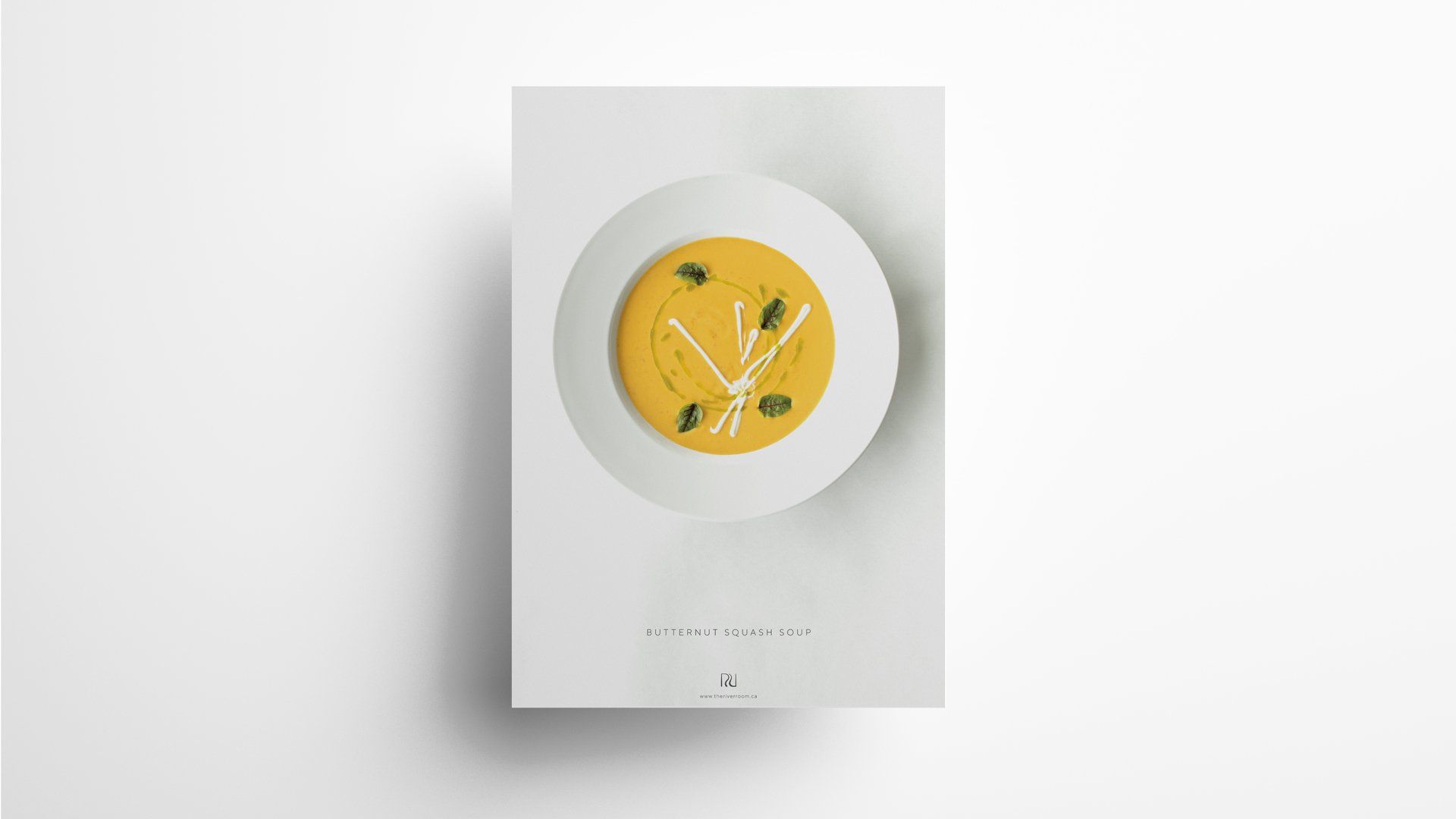 Soup in a white bowl, decorated with herbs, on a white menu card.