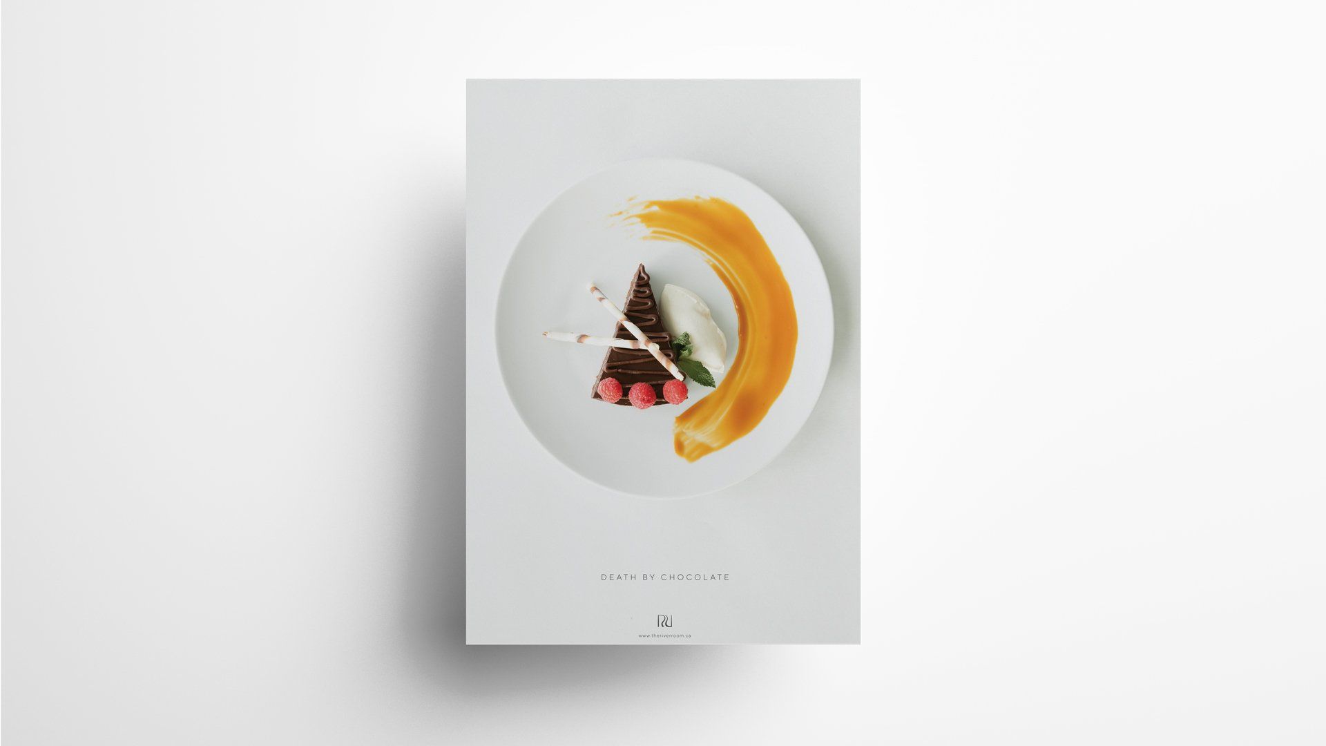 White plate with a slice of cake, sauce, and a yellow swirl on a white card.