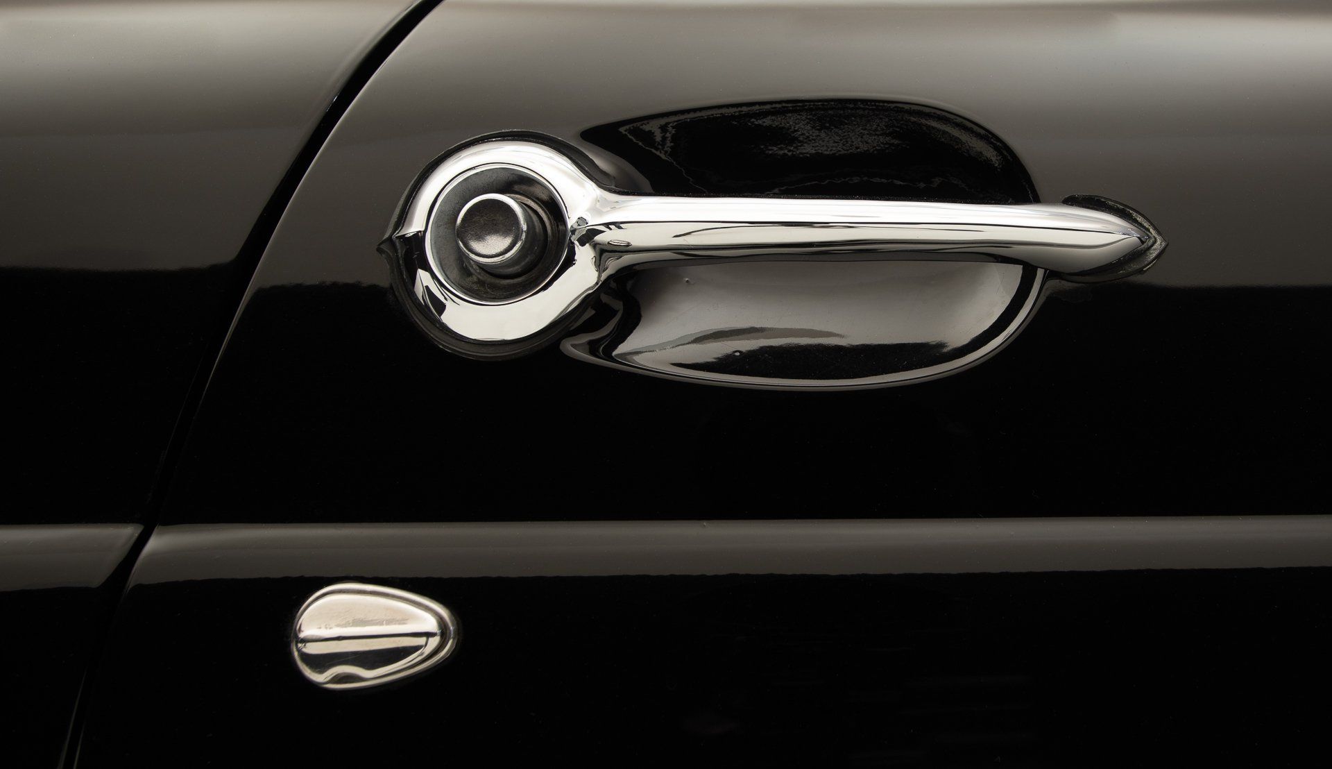 Chrome car door handle on a black vehicle.