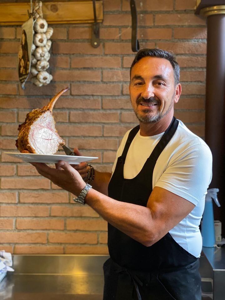 membro dello staff dell'osteria con piatti tipici della cucina fiorentina