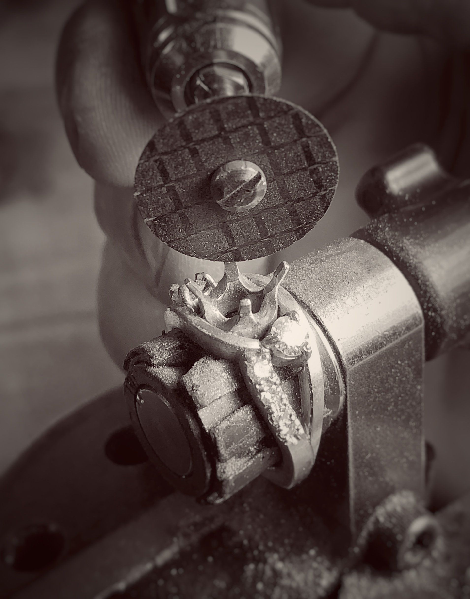 A black and white photo of a person working on a ring