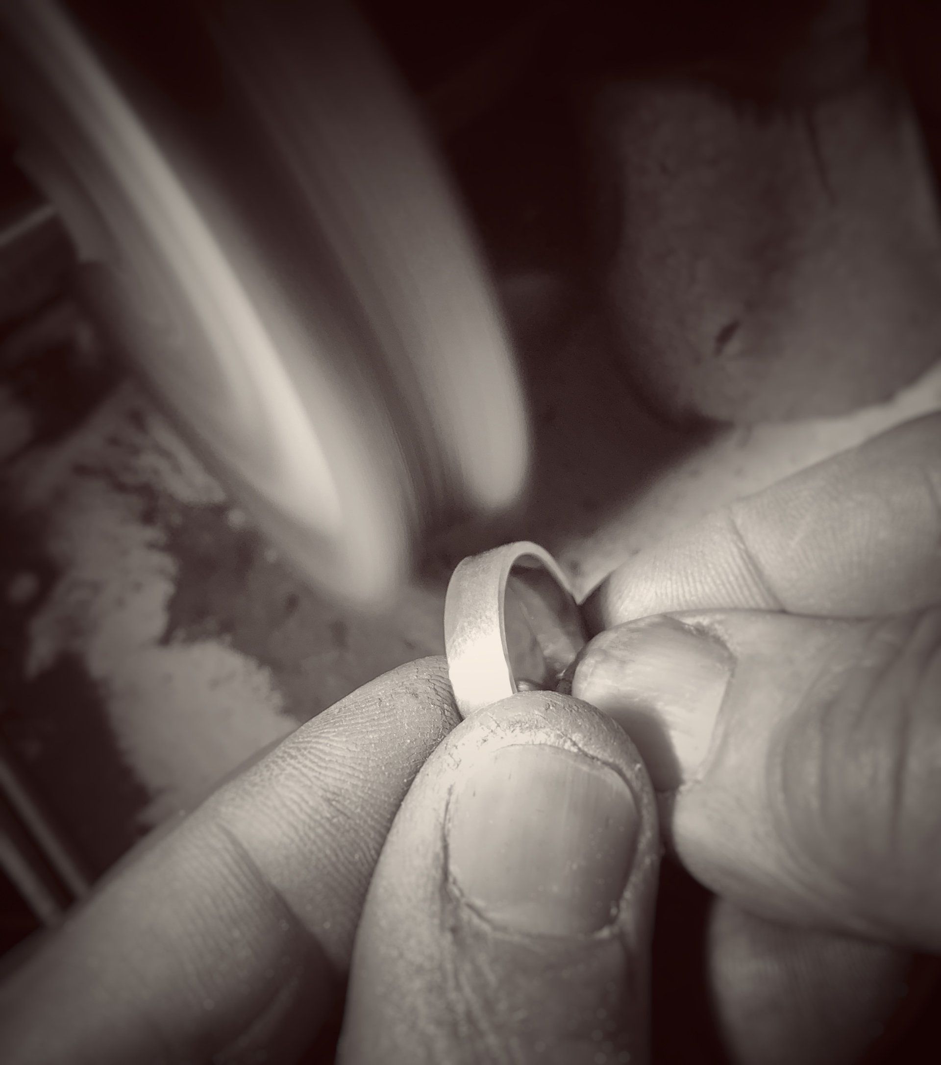 A black and white photo of a person holding a ring