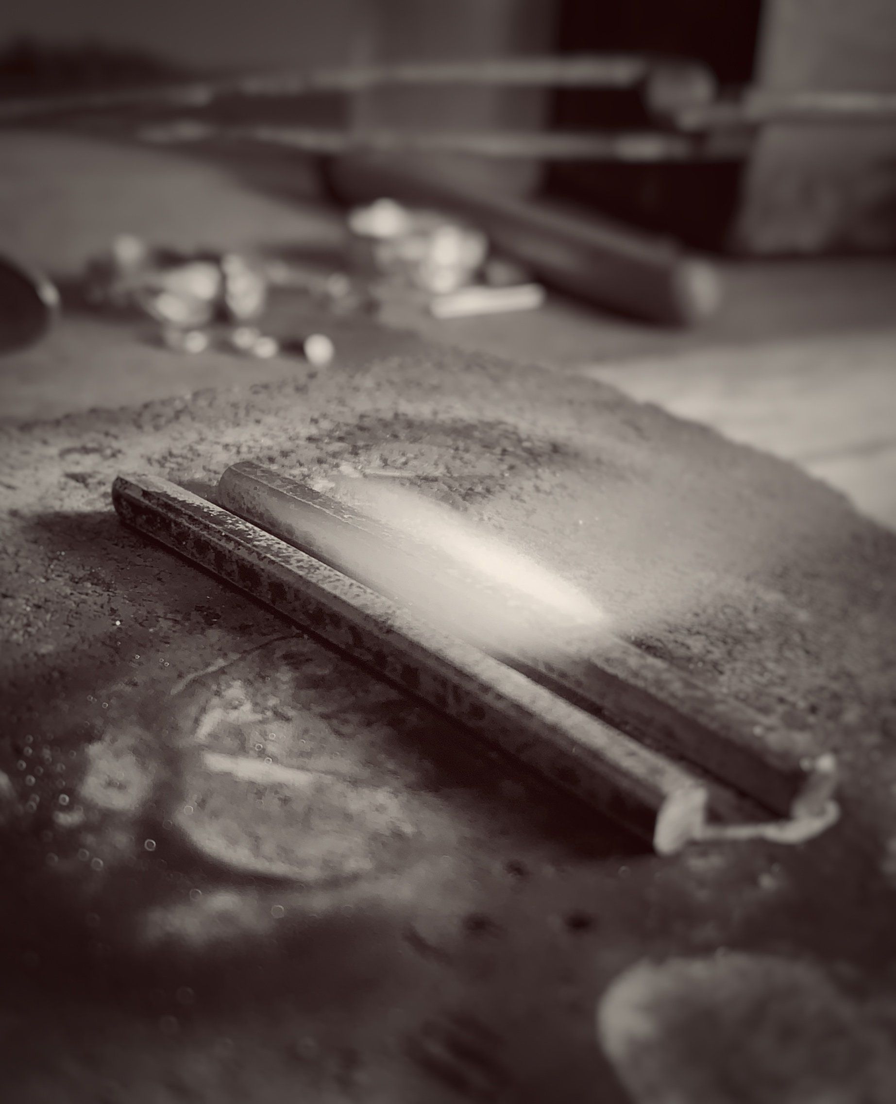 A black and white photo of a pencil on a table.