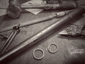 A black and white photo of a table with tools and rings on it.