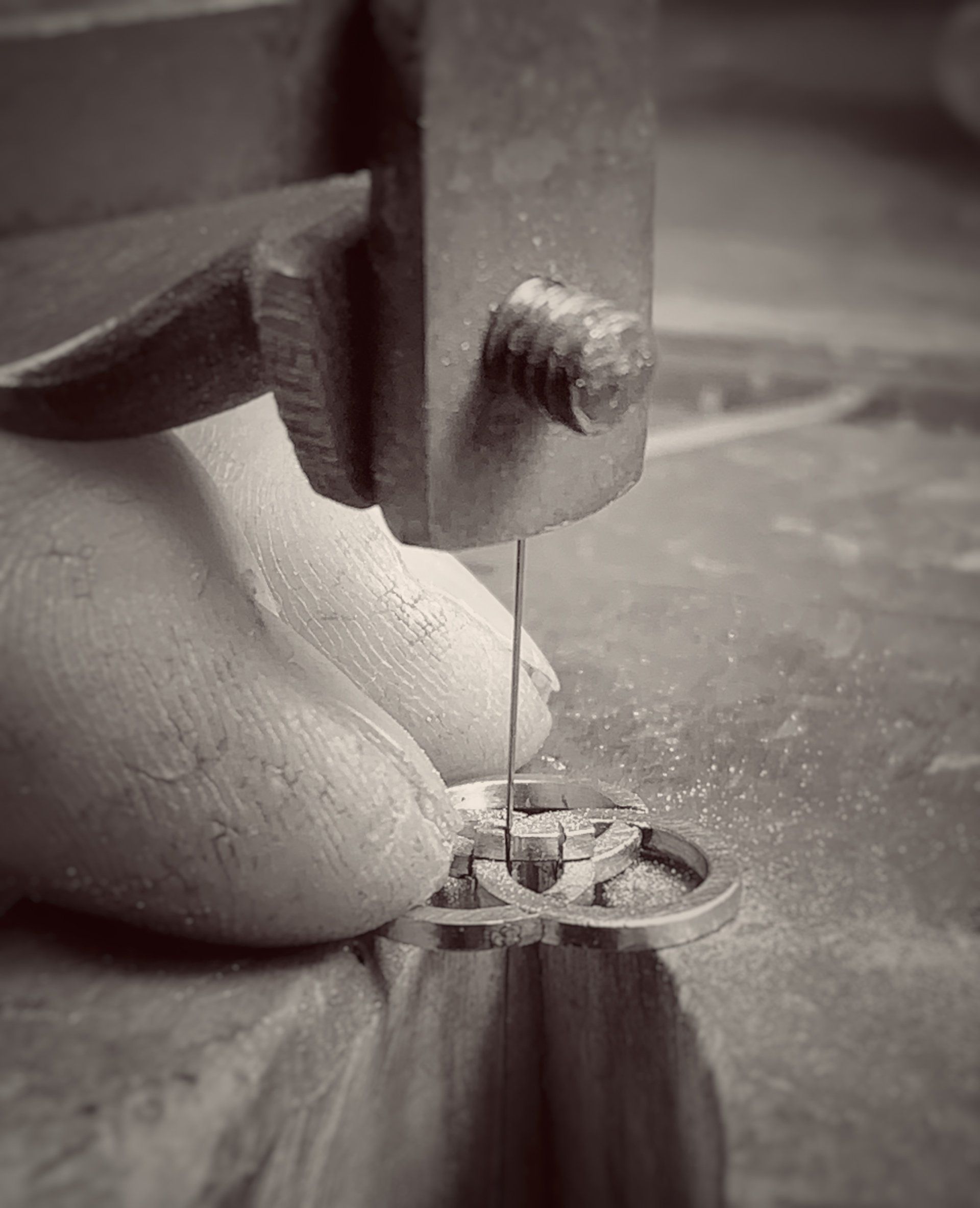A person is cutting a piece of metal with a saw.