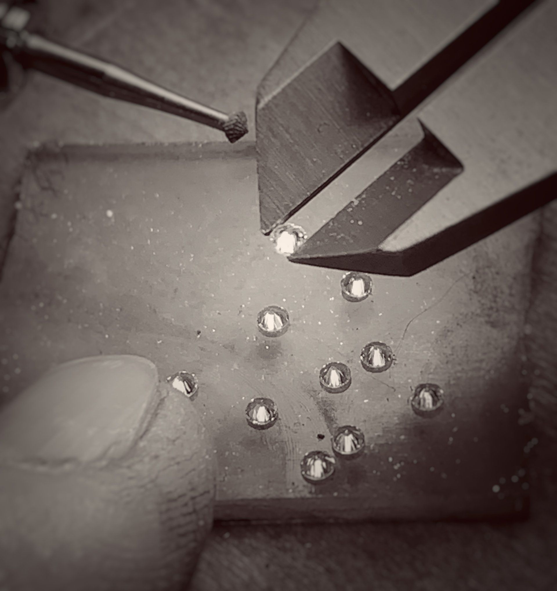 A black and white photo of a person working on a piece of metal