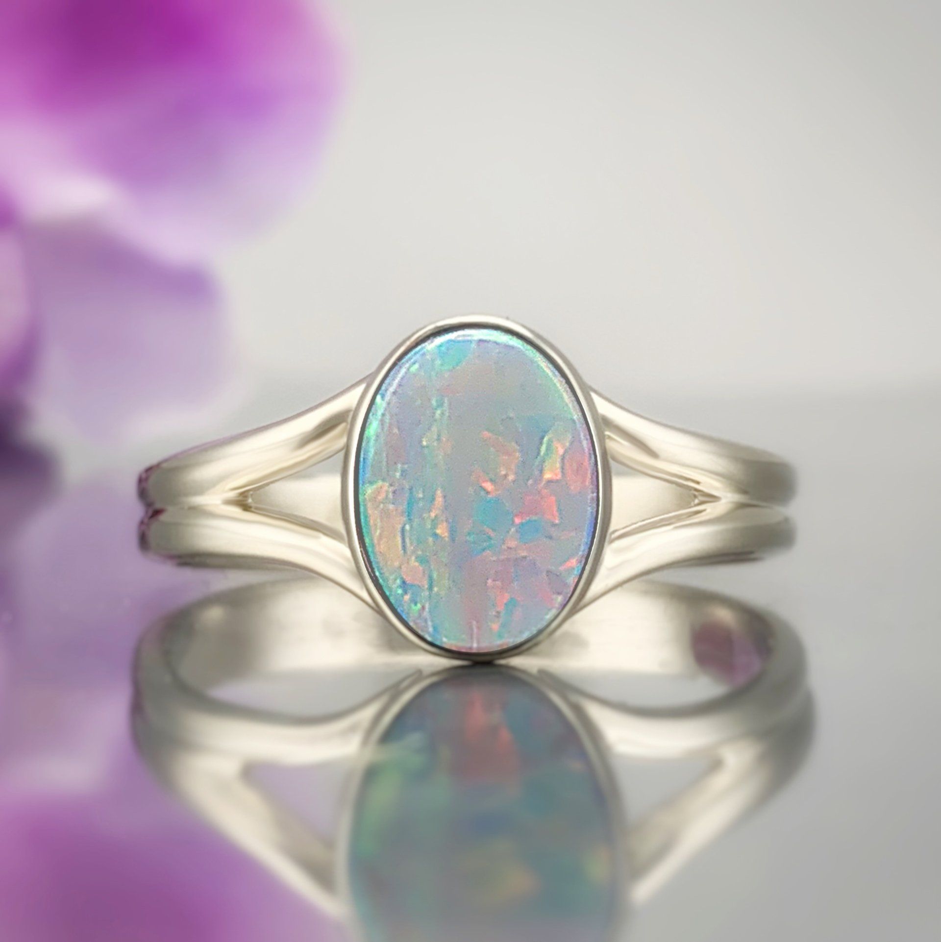 A ring with an opal in it is sitting on a table.