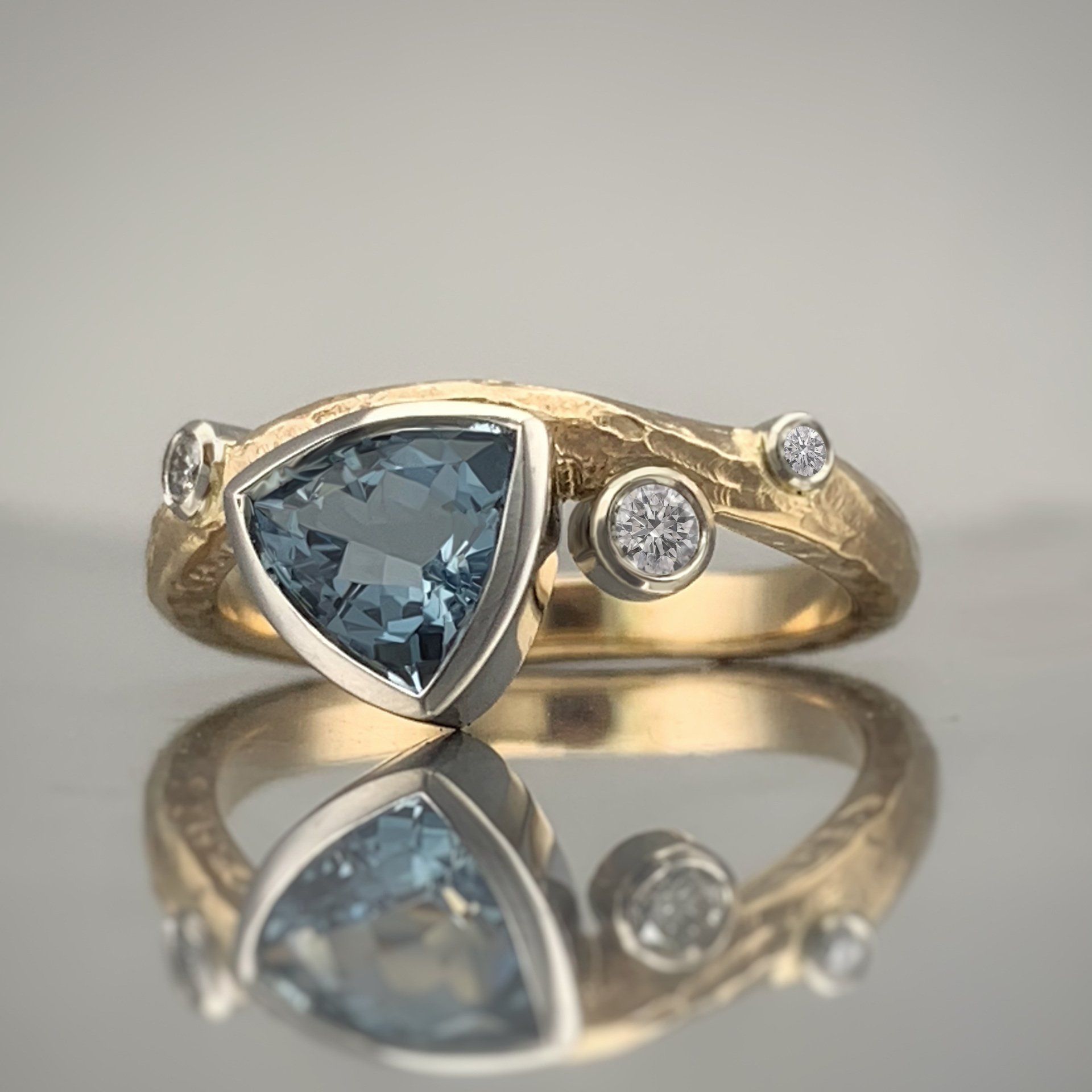 A gold ring with a blue stone and diamonds