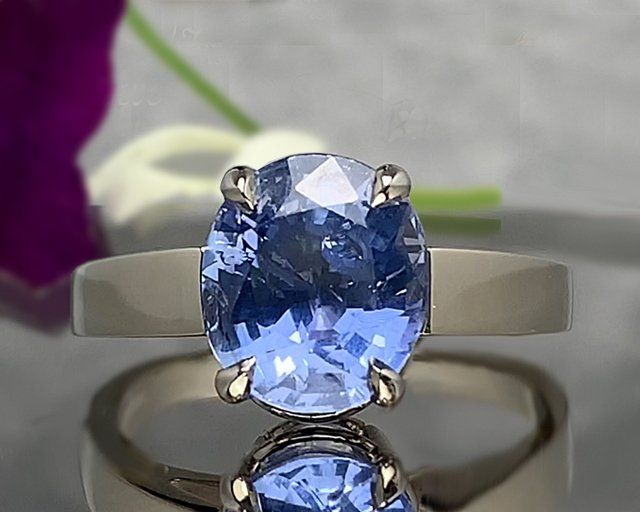 A ring with a blue stone in it is sitting on a table.