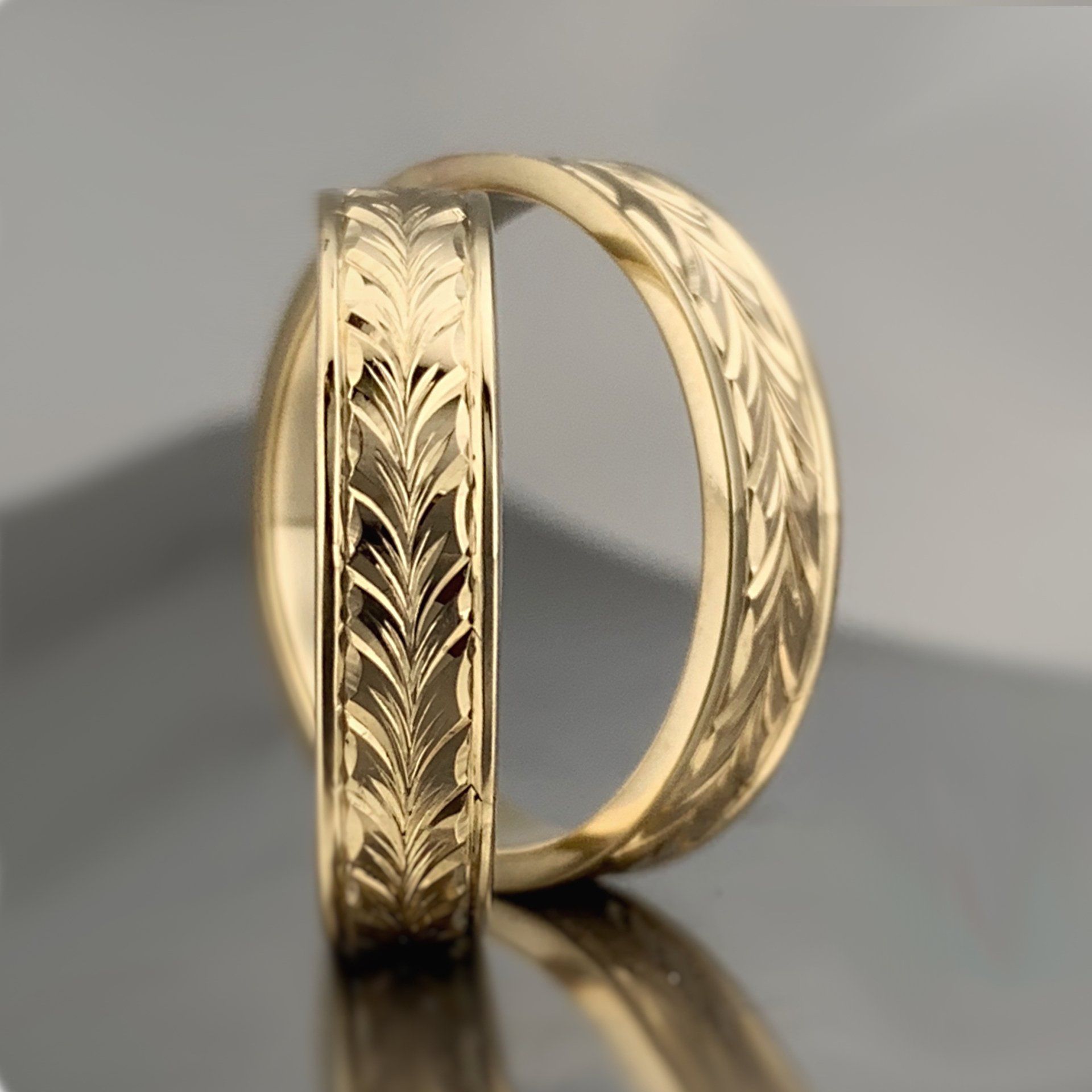 A pair of gold rings with a pattern on them