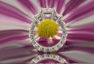 A ring is sitting on top of a purple flower.