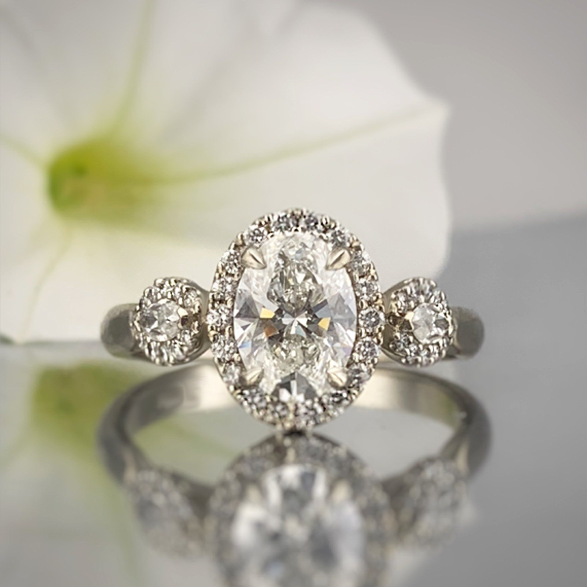 A diamond ring with a flower in the background
