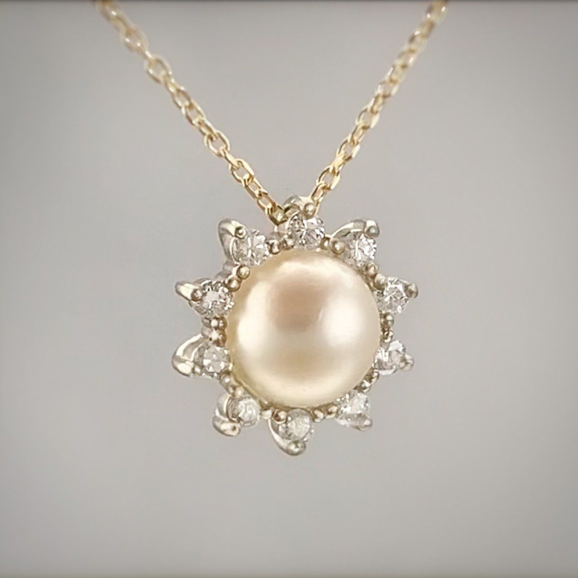 A necklace with a pearl and diamonds on it