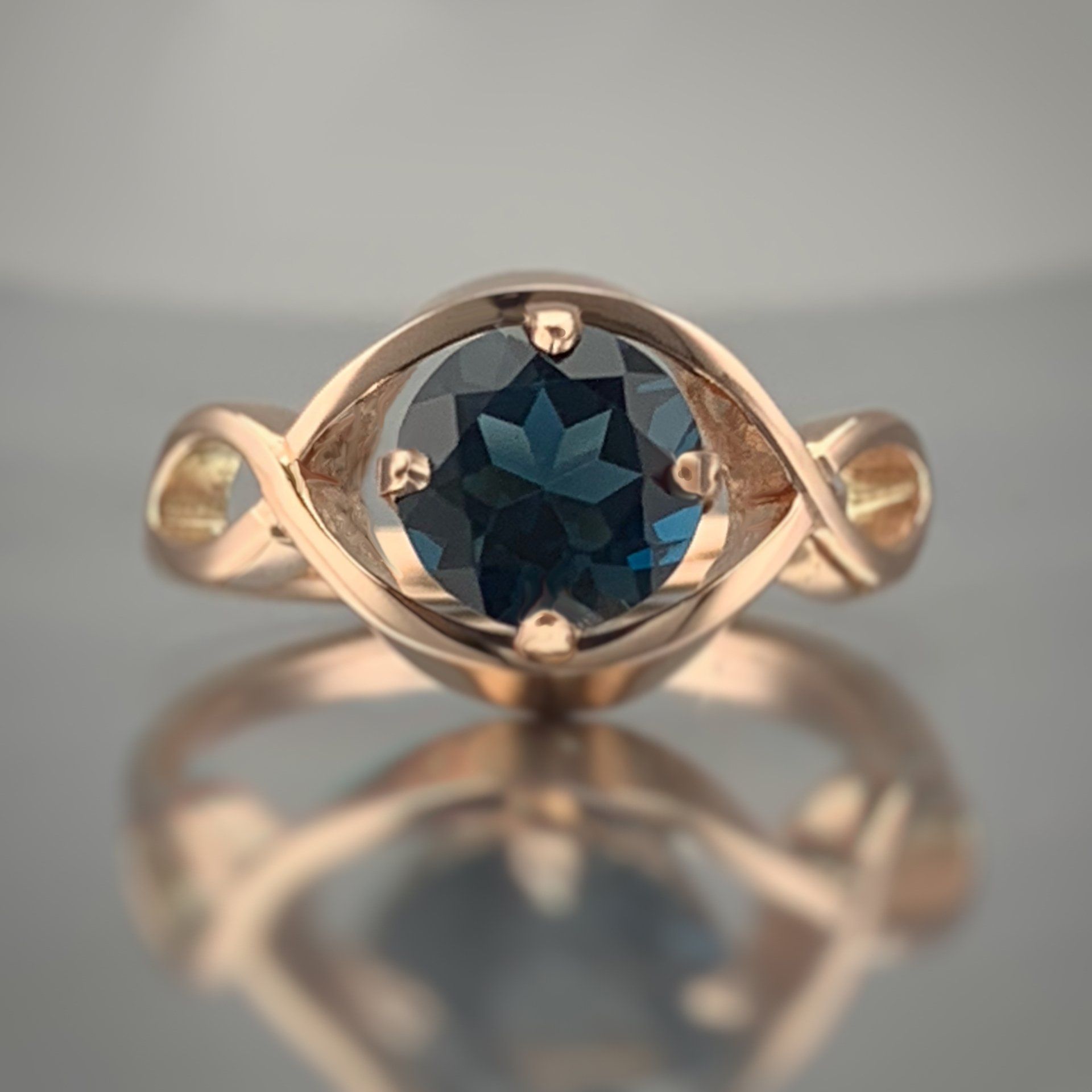 A close up of a ring with a blue stone in the center.