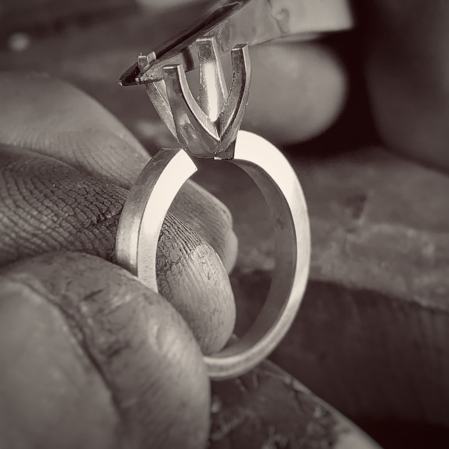 A black and white photo of a person holding a ring