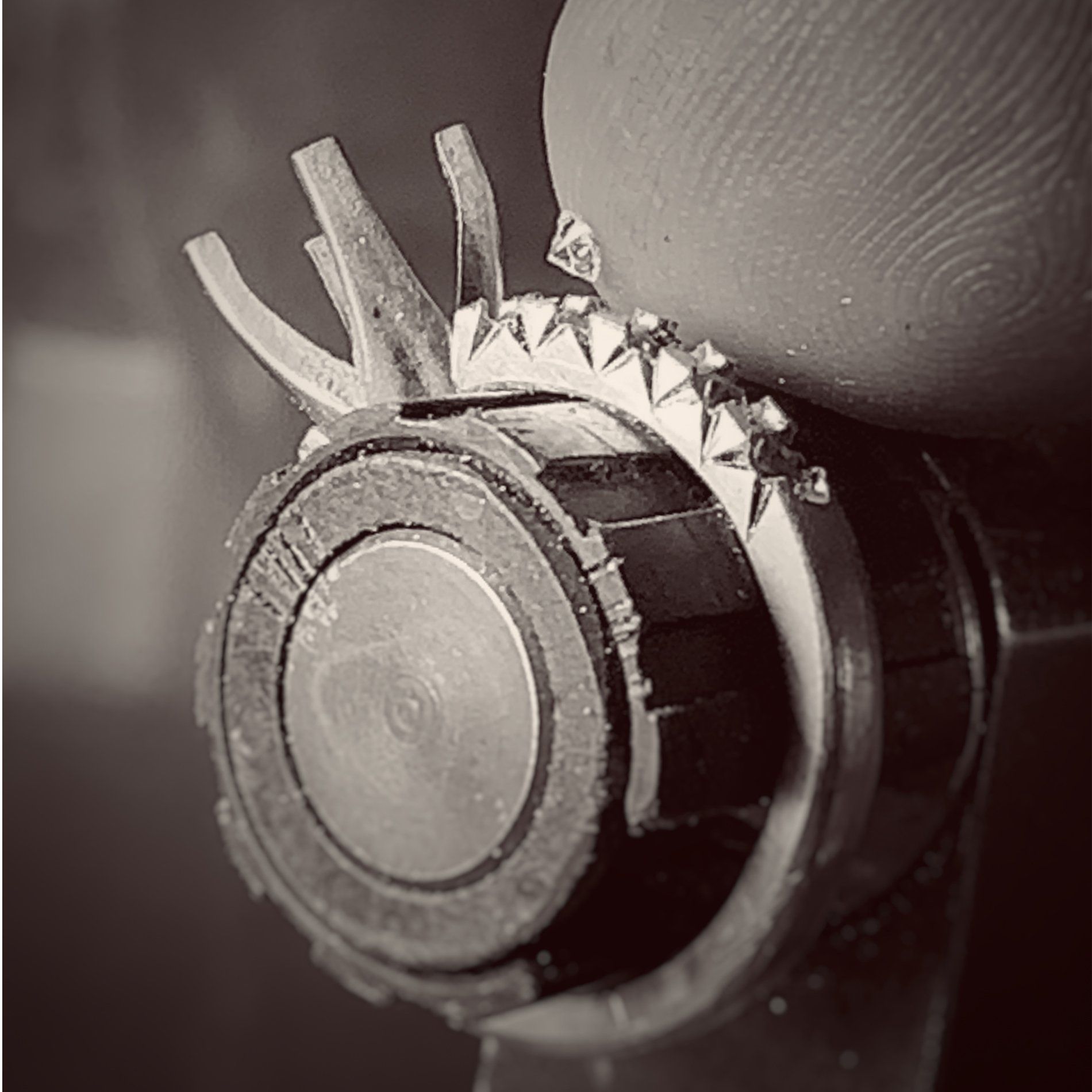A black and white photo of a person holding a piece of metal