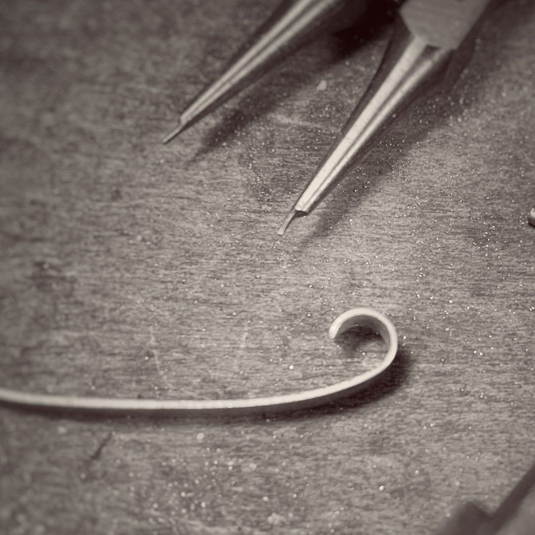 A pair of pliers sitting on top of a wooden table next to a piece of wire.