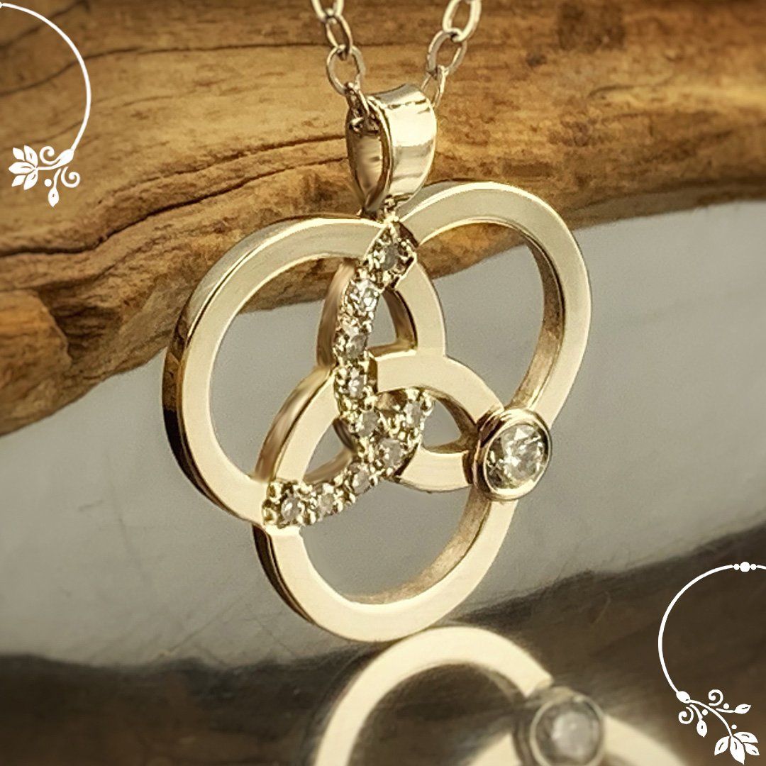 A gold necklace with a diamond in the middle