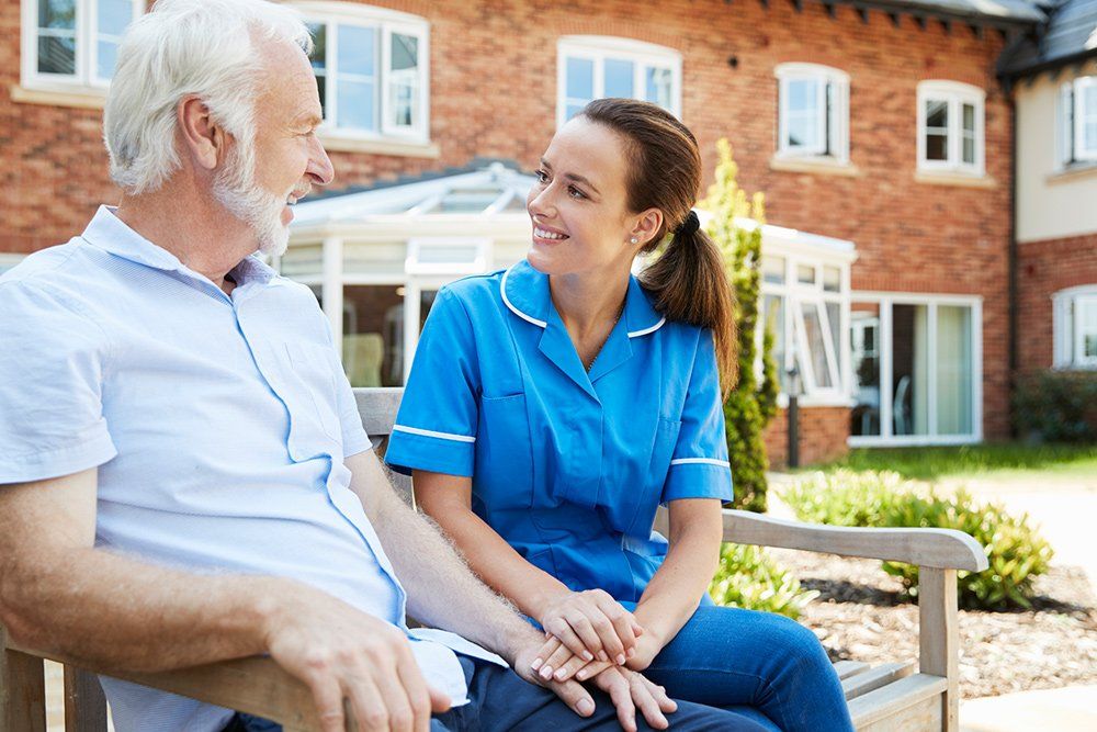 Retirement Home Care — Senior Man Talking with Nurse in Columbus, OH Retirement Home Care — Senior Man Talking with Nurse in Columbus, OH