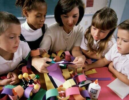 Female teacher teaching her students arts and crafts in Lombard, IL Students learning during child care in Lombard, IL