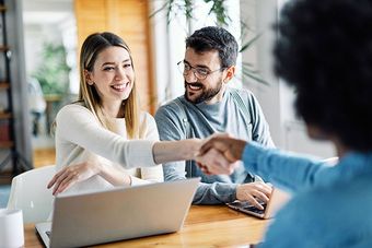 Young couple shaking hands deal contract real estate investment