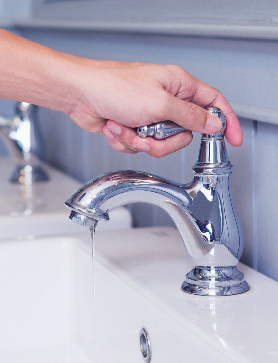 Person Turning A Silver Faucet Person Turning A Silver Faucet